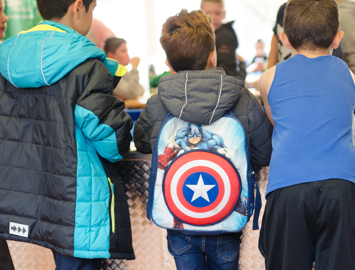 Jungen stehen im Kreis, einer trägt einen Powerranger Rucksack